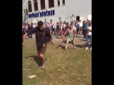Толпа наблюдает как мужик пьяный пытается надеть кросовку и поддерживает его