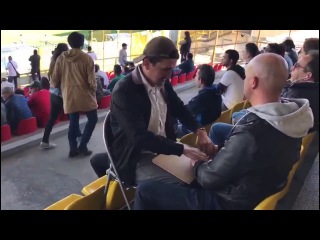 Deaf-blind man enjoys football (soccer) match with help. Слепо-глухой мужчина наслаждается футболом благодаря помощи друга.