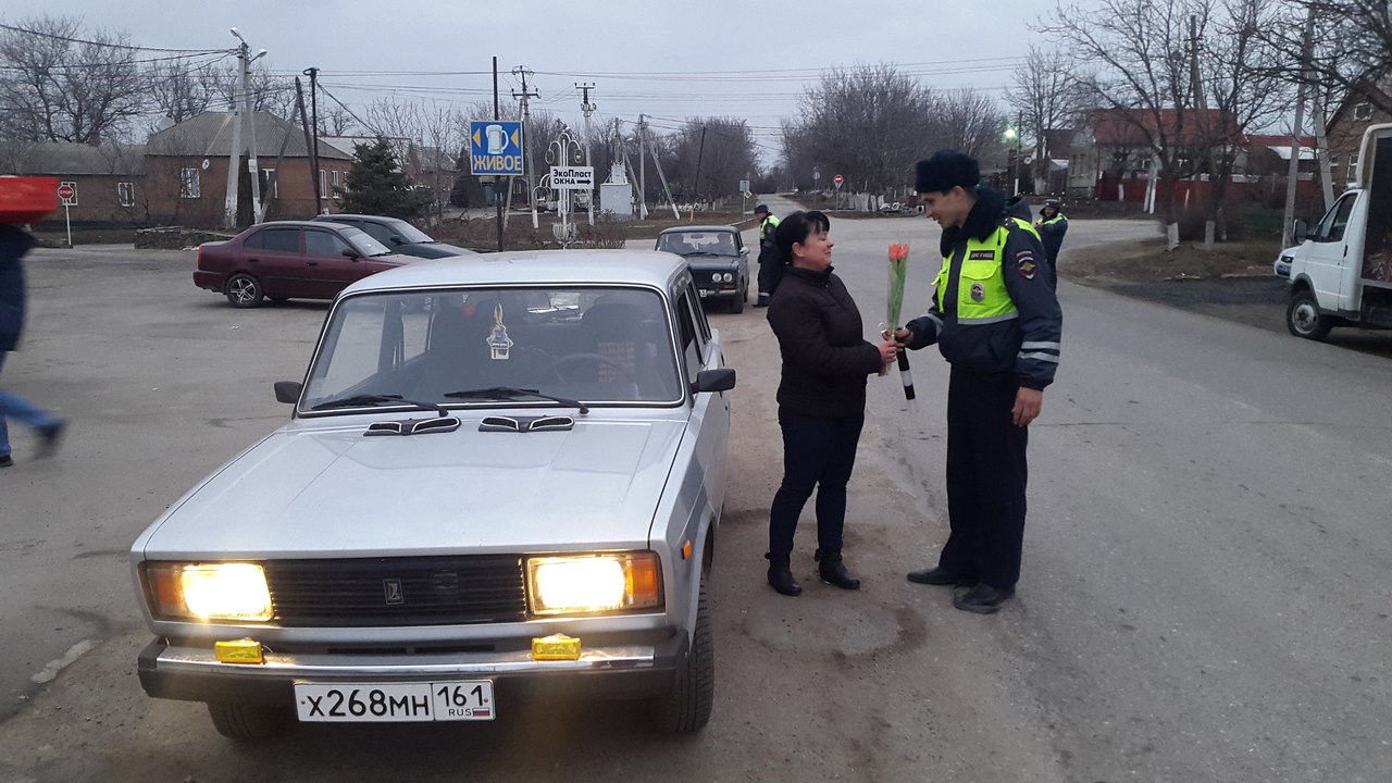 Неклиновские сотрудники ГИБДД в честь праздника вручили автоледи цветы