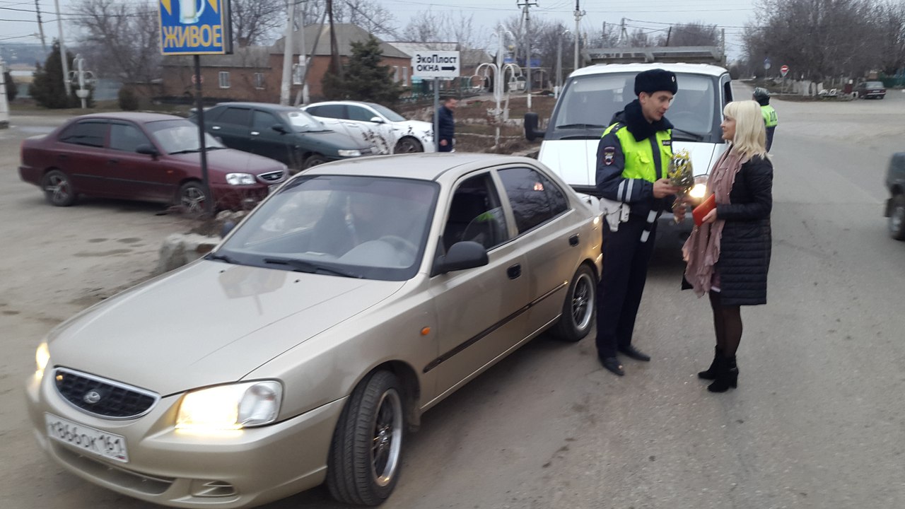 Неклиновские сотрудники ГИБДД в честь праздника вручили автоледи цветы