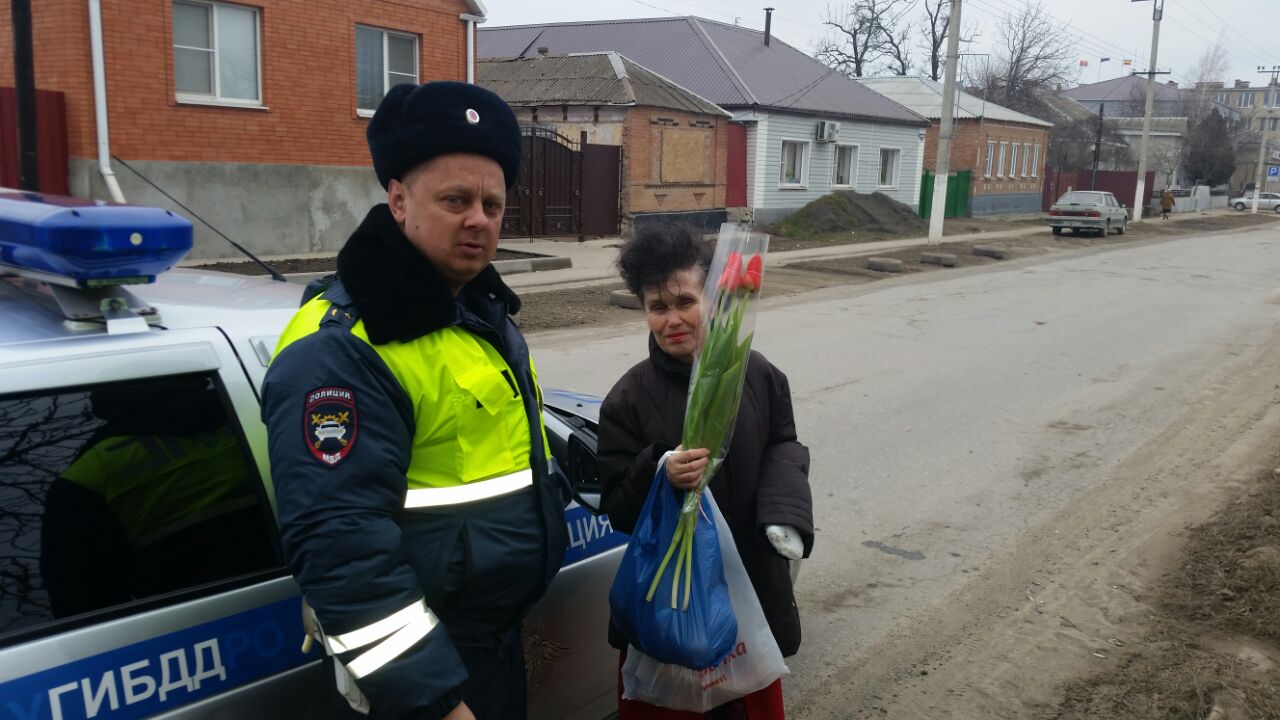 Неклиновские сотрудники ГИБДД в честь праздника вручили автоледи цветы