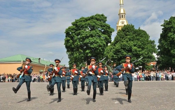 Фото: В день рождения Петербурга состоялась первая в этом году церемония развода почётного караула <br><br>Теперь каждую субботу в 11:55 горожане смогут увидеть впечатляющий плац-парад с демонстрацией виртуозных приёмов владения оружием.<br><br>В летний период в Петропавловской крепости на территории Нарышкина бастиона каждую субботу после традиционного полуденного выстрела проходит церемония развода почётного караула. По традиции самые зрелищные элементы церемонии — плац-парад с демонстрацией приёмов с самозарядным карабином и вынос флагов России и Петербурга.<br><br>Детали церемониала были разработаны ещё в конце XVIII века, в эпоху правления Павла I, а его особенности сохранялись до начала ХХ века: в те годы церемония смены караула проводилась на площади перед Петропавловским собором.<br><br>Караульная служба просуществовала до октября 1926 года — до упразднения комендантского управления. В настоящее время церемония носит символический характер, а её детали разработаны Военной комендатурой Петербурга. В церемонии принимает участие личный состав 165-й отдельной стрелковой роты почётного караула и оркестр Штаба Западного военного округа.